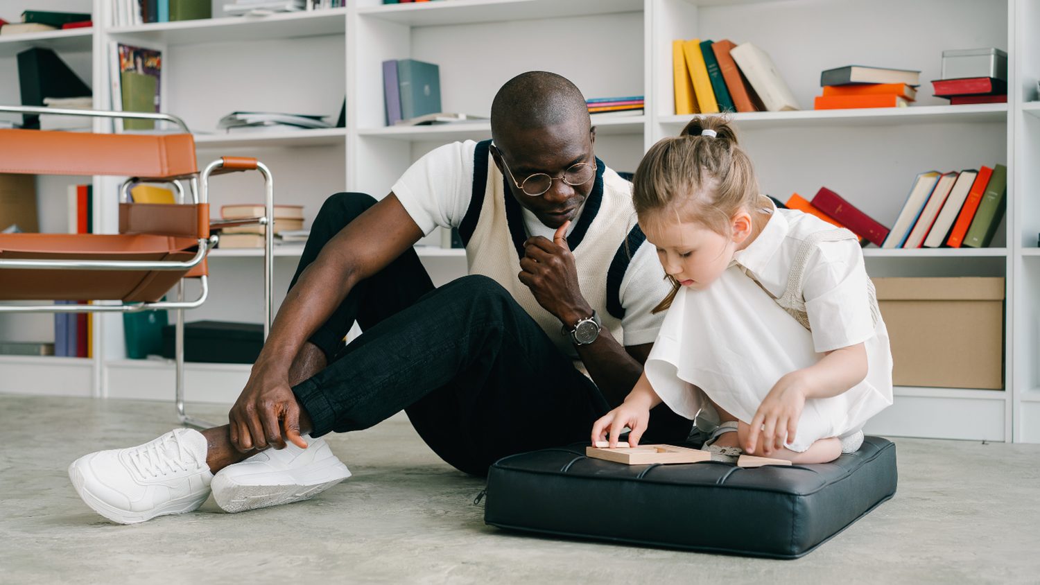 Man Watches Little Girl on Cushion