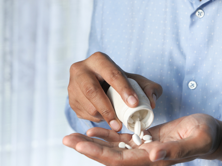 A Jar of Pills Being Poured into a Hand