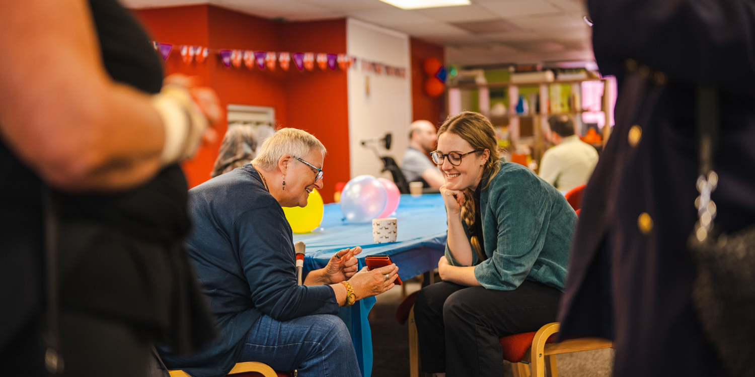 Two People Looking at a Phone at an Event