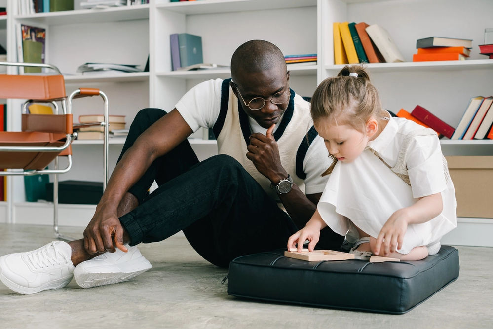 Man Watches Little Girl on Cushion